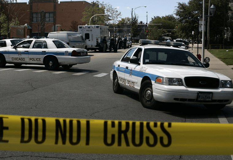 Several Chicago police cars parked across a crossing