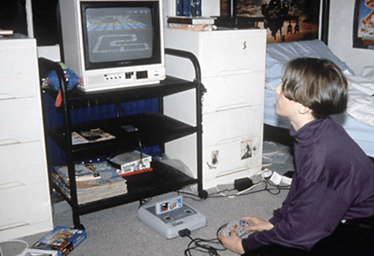 A boy in his bedroom playing Chrono Trigger on a Super Nintendo