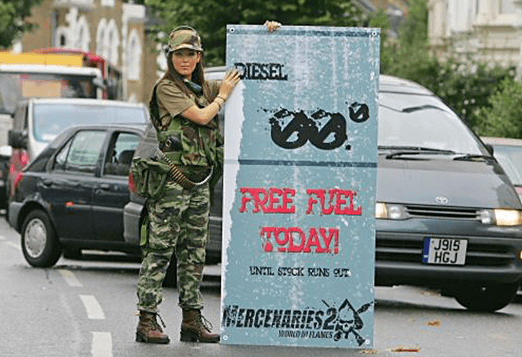 Military girl holding free fuel sign for Mercenaries 2: World in Flames publicity stunt