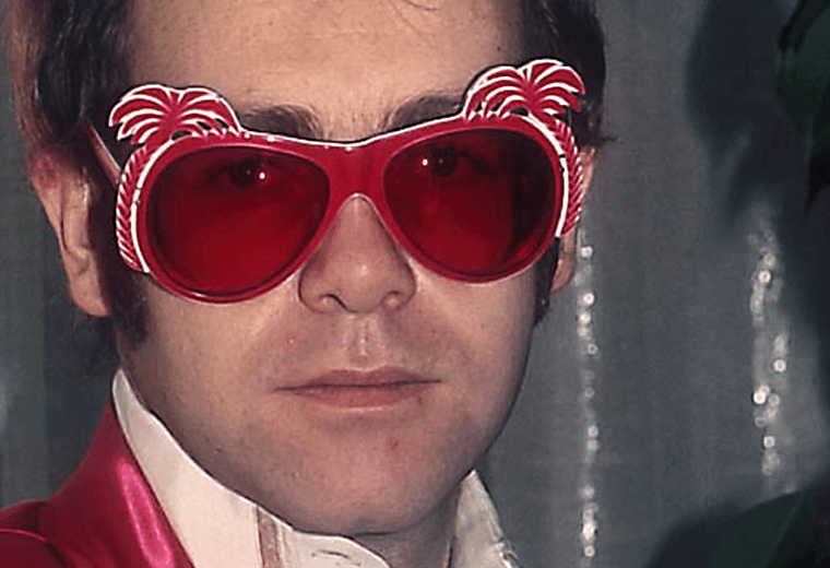 Elton John wearing palm tree sunglasses